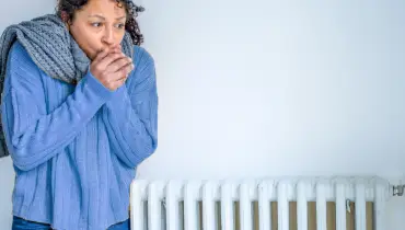 Black woman with home heating problem feeling cold | Aire Serv of Birmingham.