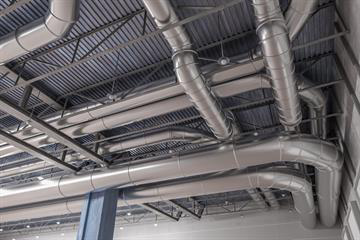 Exposed stainless steel ductwork on ceiling.