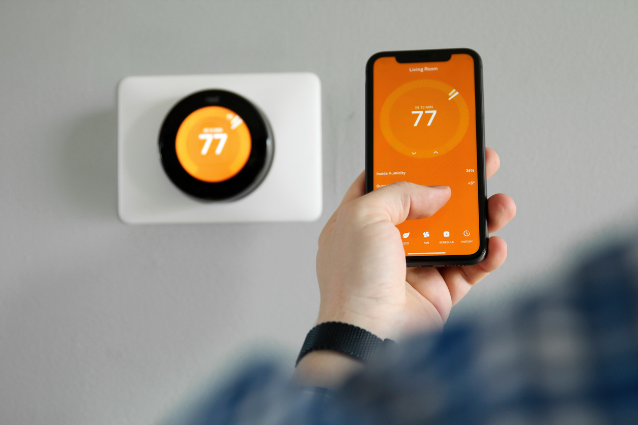 Homeowner controlling the heating system on thermostat