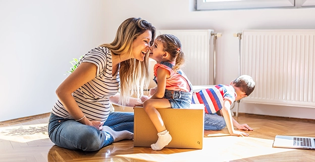 A woman playing with children in a living room.