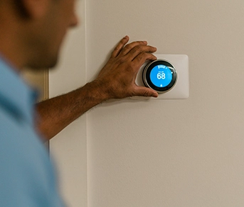 Aire Serv tech adjusting a thermostat.