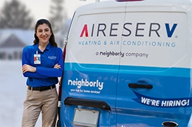 Aire Serv technician standing beside the back of an Aire Serv van.