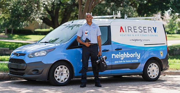 Aire Serv technician standing in front of an Aire Serv van.