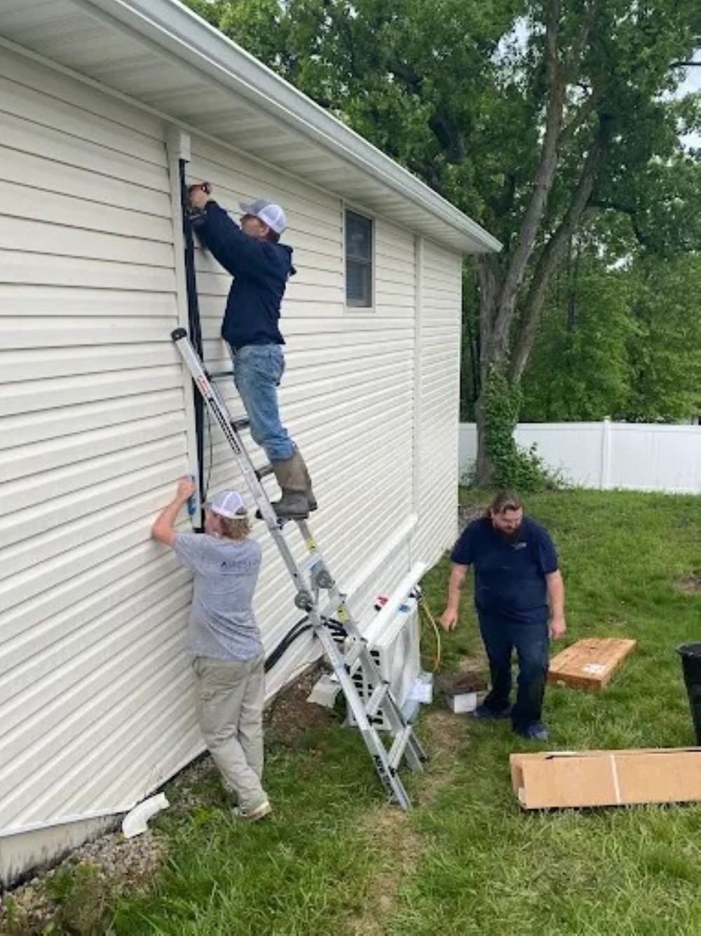 3 of Our Technicians Working Together Outside a Customers House