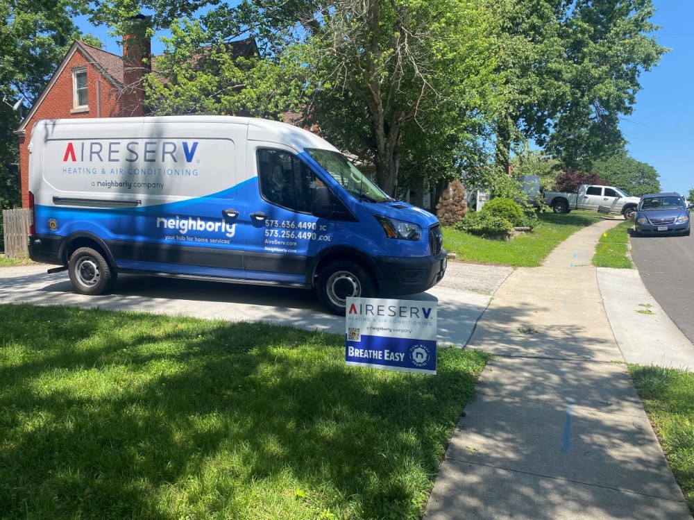 Aire Serv Van In A Driveway With An Aire Serv Yard Sign