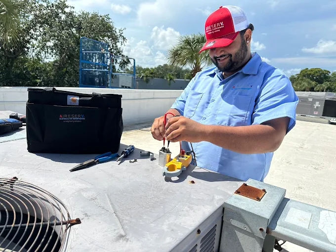 Service Technician Performing Maintenance On A Rooftop Commercial HVAC Unit