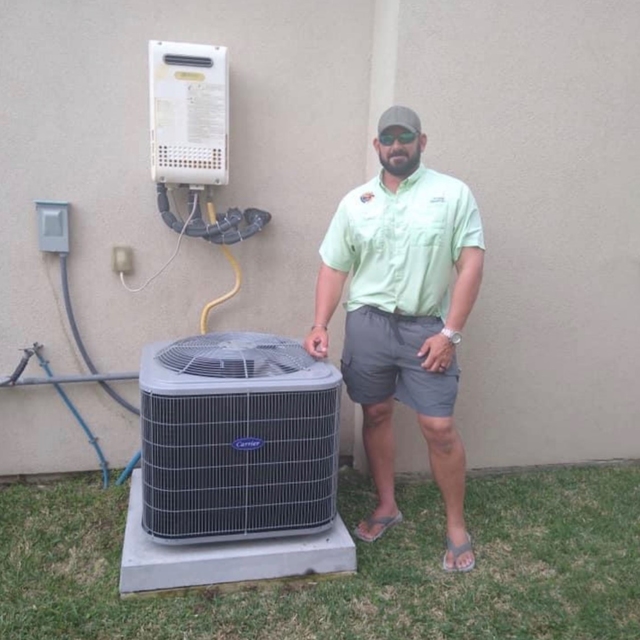 Happy customer standing next to a newly installed AC unit at their home