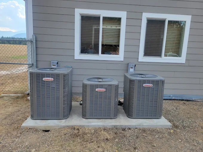 Three newly installed heat pump units positioned outside a home.
