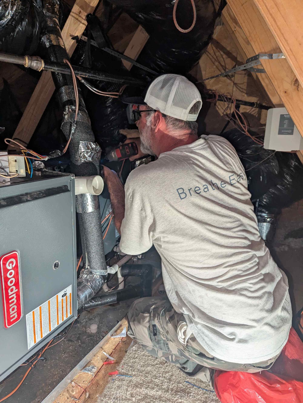 Aire Serv technician repairing a furnace in an attic