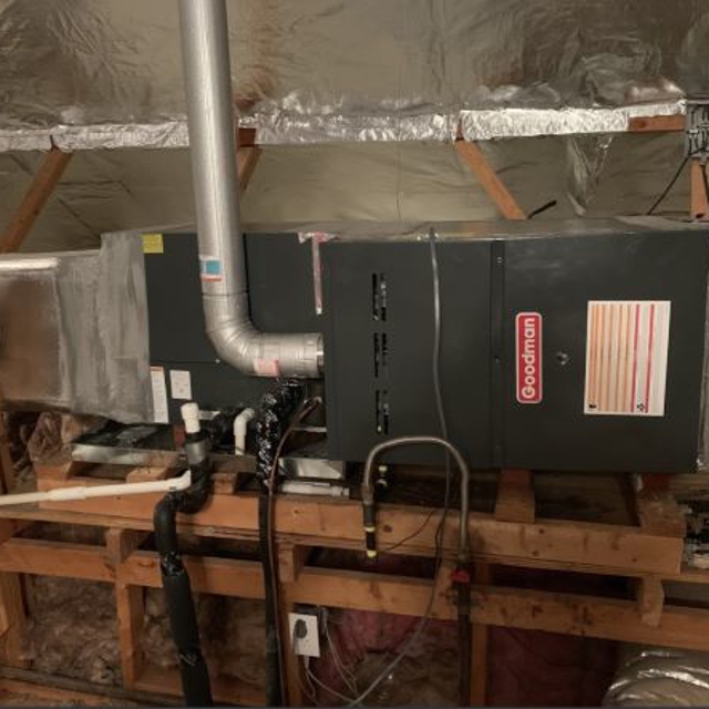 Goodman air handler in attic of home surrounded by insulation.