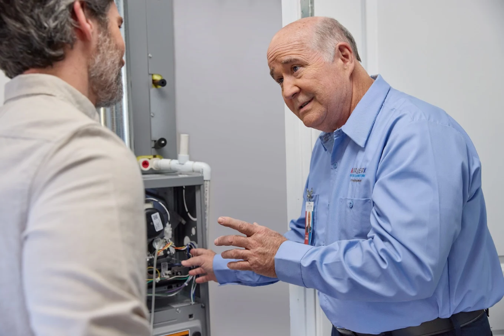Service Technician Explaining An Open Furnace To A Customer