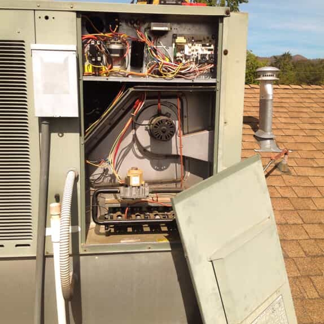 Rooftop HVAC unit opened with electrical and mechanical components exposed