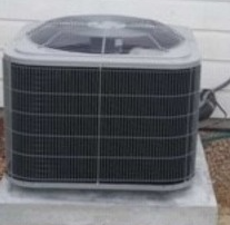 Close-up of a single air conditioner condenser unit outside a home