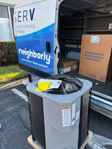 Brand New AC Unit Outside A Home With A Service Van And Open Doors
