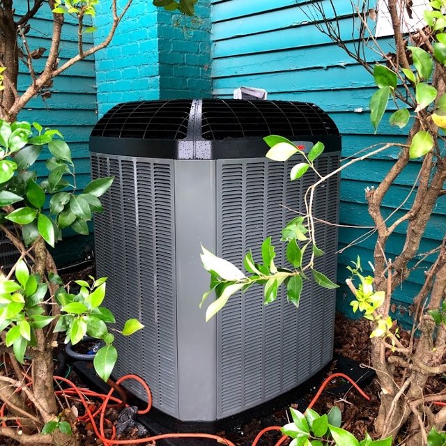 Close-up of a newly installed outdoor condenser unit at a home