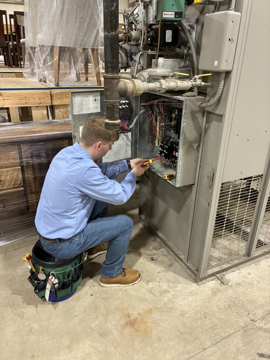 HVAC service technician working on an air rotational unit inside a residential system for maintenance and repair.