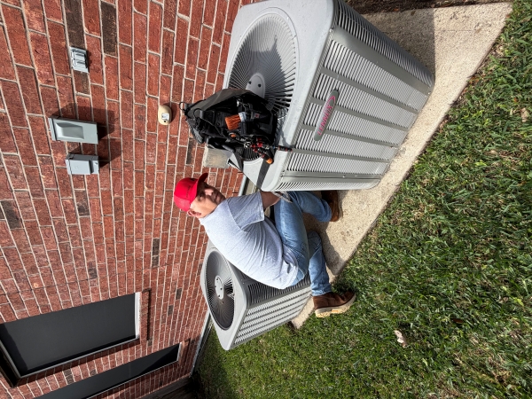 Technician Kneeling Down Next to Outdoor AC unit