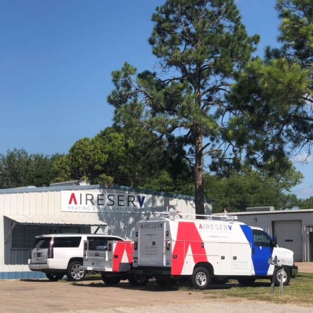 Two Aire Serv of Victoria service trucks parked outside the warehouse