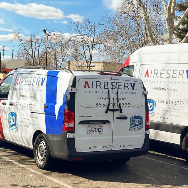 Two Aire Serv of Stockton service vans parked outside a building