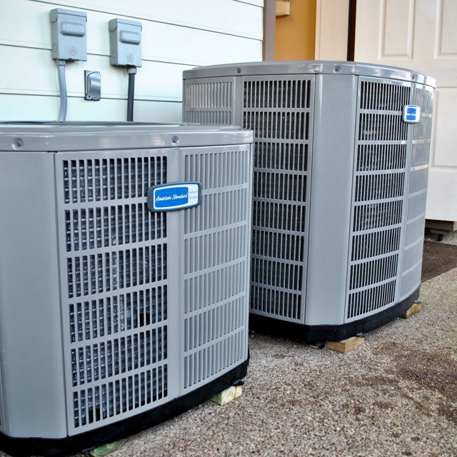 Two air conditioner condenser units installed outdoors for residential cooling