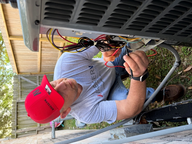 Technician Checking Wires in HVAC Unit