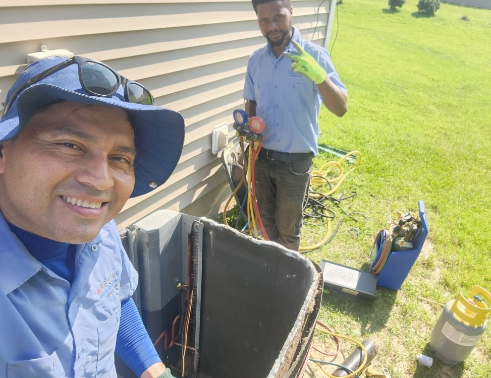 Two of our team members cleaning out an AC