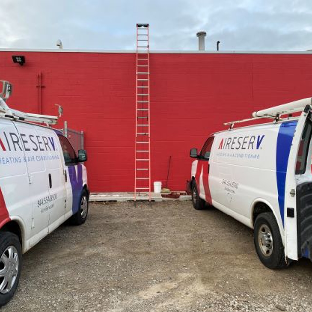 Vans outside of red building