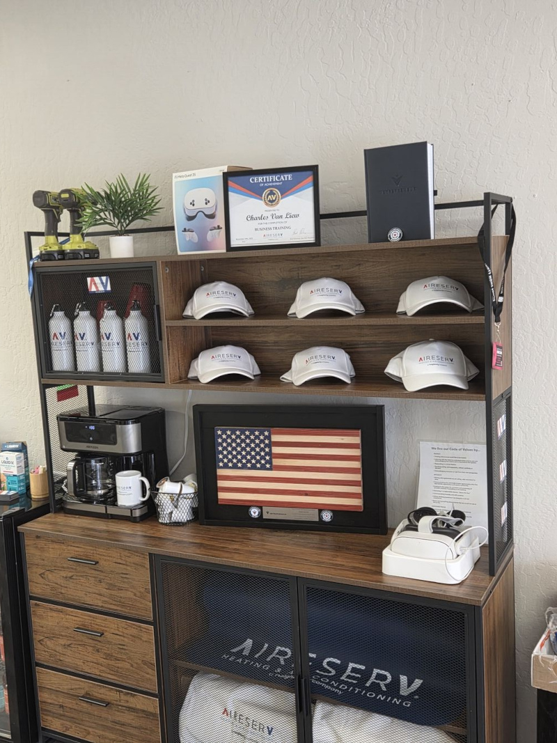 A professional Vetrepeneur award plaque displayed on a wooden cabinet in the Aire Serv of E Glendale-Peoria office, honoring veteran business ownership.