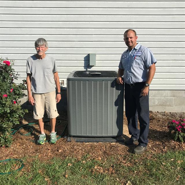two people standing next to AC unit