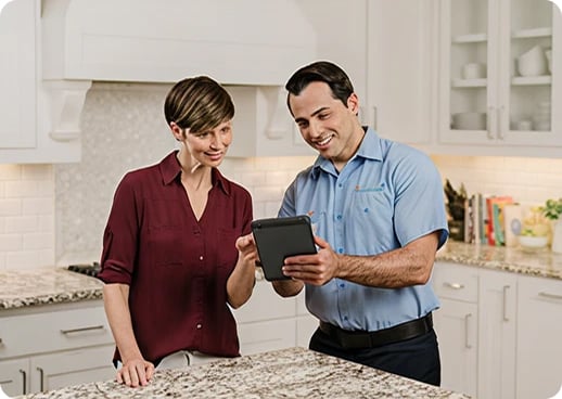 Male Aire Serv technician explaining services customer.