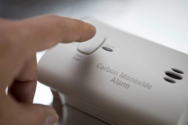 A man pushes a button on a carbon monoxide alarm. | Aire Serv of North Central Arizona 