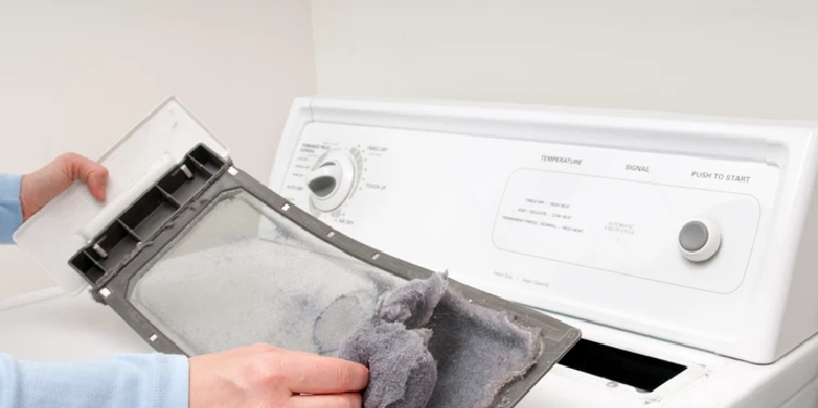 A man removes lint from his clothes dryer’s lint trap. | Aire Serv of North Central Arizona