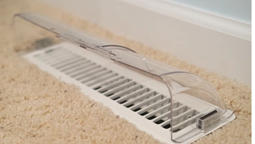 Close-up of floor air vent with plastic diverter.