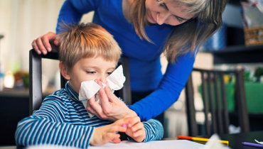 Mother helping her son blow his nose