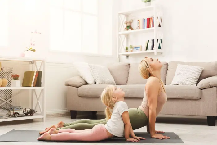 Two people doing yoga in a clean home.