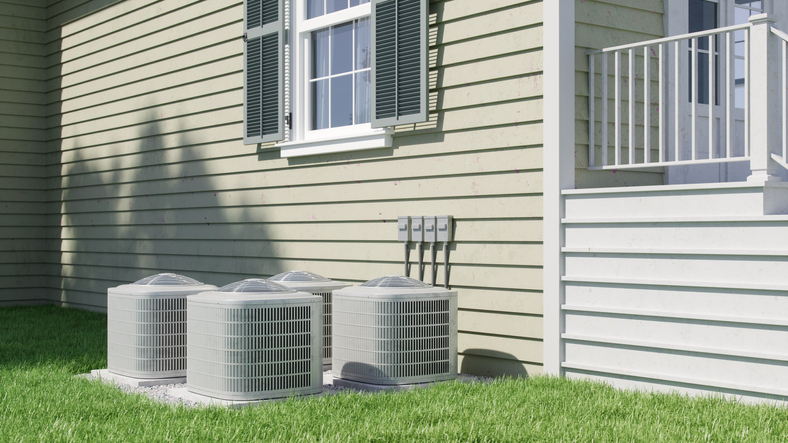 Four air conditioning units are seen outside of a home.