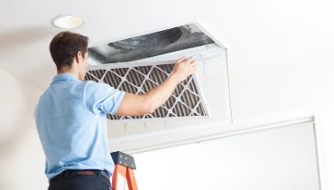 An HVAC professional opens up an air duct to prepare for cleaning.