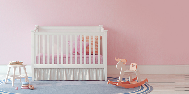 Baby's room with crib, stool, rocking horse, and pink walls