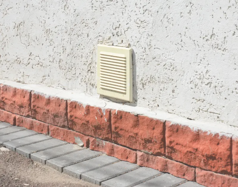 Stucco wall with vent.