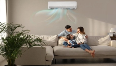 A man, woman, and child sit on a couch and enjoy cool air from their air conditioner. | Aire Serv of Citrus County