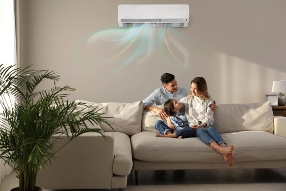 A man, woman, and child sit on a couch and enjoy cool air from their air conditioner. | Aire Serv of Citrus County