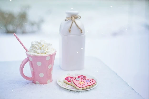 Valentine's Day cookies and mug on snow-covered table