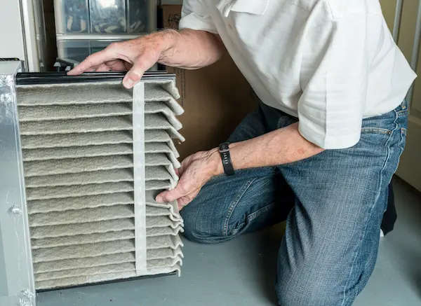 Man swapping out an HVAC air filter.