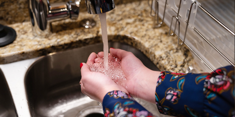 Woman washing her hands in kitchen sink