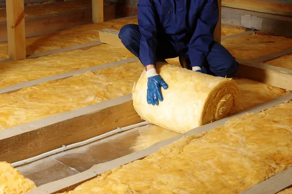 Service professional insulating attic with yellow foam.
