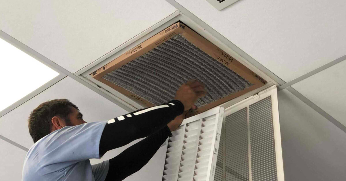 Homeowner changing filters on a whole house fan.