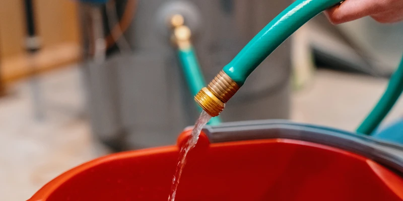 Hose filling up bucket with water