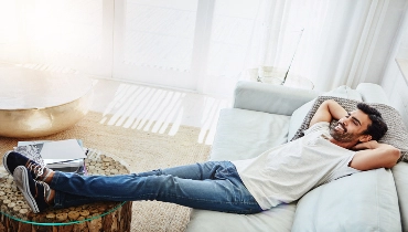 Shot of a man relaxing on the sofa at home | Aire Serv® of Central Illinois