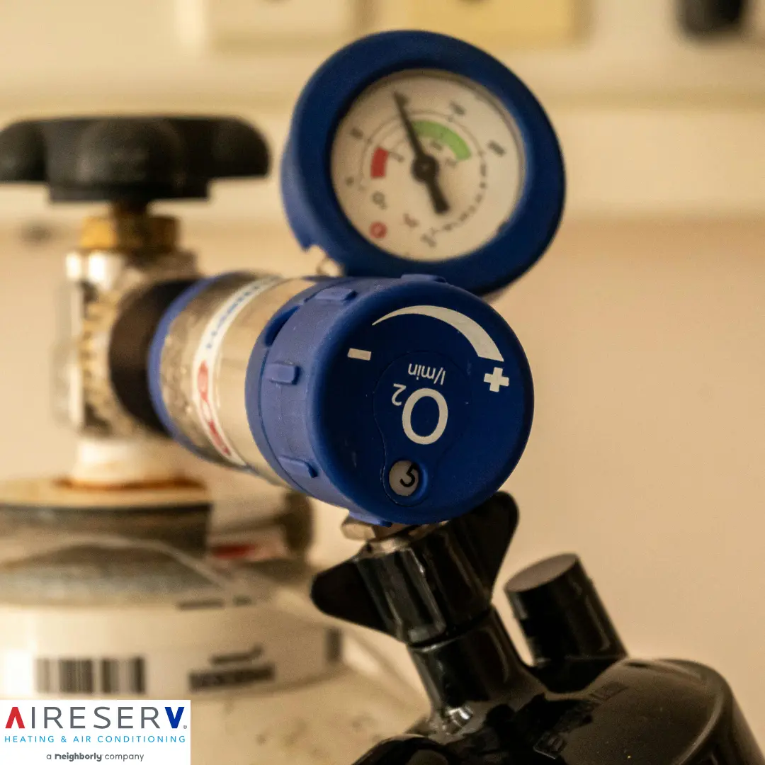 A close-up of a medical oxygen regulator attached to a tank.