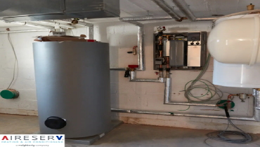 A basement utility room featuring a large grey cylindrical water heater.